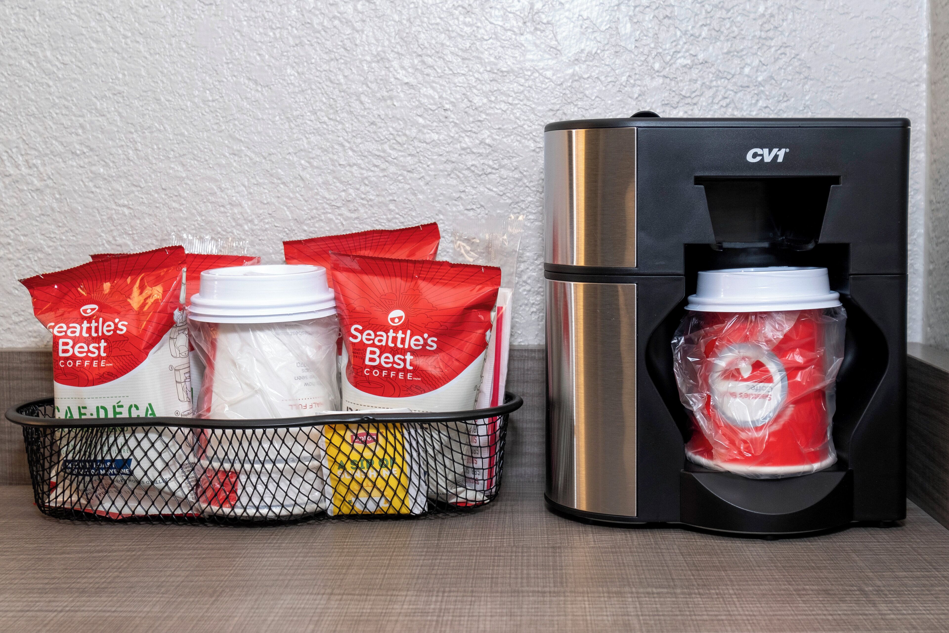 Una cafetera y una cesta con cápsulas de café.