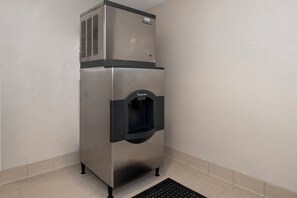 A stainless steel commercial refrigerator with a water dispenser, located in a corner with tiled flooring. - Red Roof Inn PLUS+ Boston - Mansfield/ Foxboro (Mansfield)