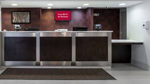 A reception desk with a digital display, a 'Free Wi-Fi All Rooms' sign, and a security camera. - Red Roof Inn PLUS+ Boston - Mansfield/ Foxboro (Mansfield)