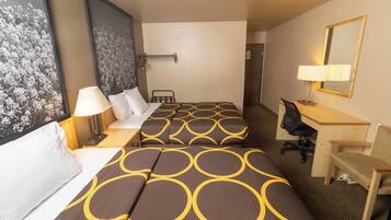 A hotel room with two beds, a desk, a chair, a lamp, and a large framed picture on the wall.