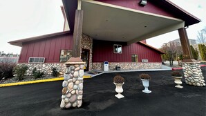 A building with a sloped roof, stone pillars, and a stone wall. - FairBridge Inn & Suites Moscow/Pullman (Moscow)