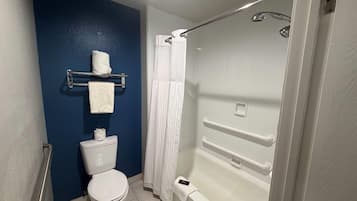 A bathroom with a toilet, a shower with a grab bar, and a towel rack.