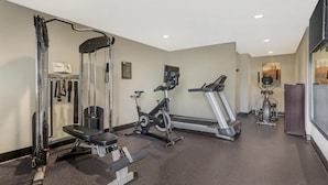 A gym with various exercise equipment including a bench press, a treadmill, and a stationary bike. - Best Western Plus Pleasanton Inn (Pleasanton)