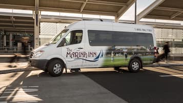 A white van with "The Marina Inn" branding parked at a bus station.