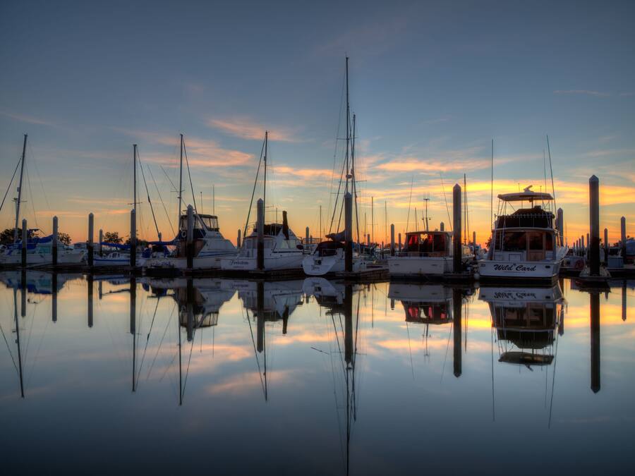 A marina with boats docked at sunset.