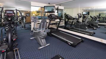 A gym with treadmills, elliptical machines, and weight equipment.