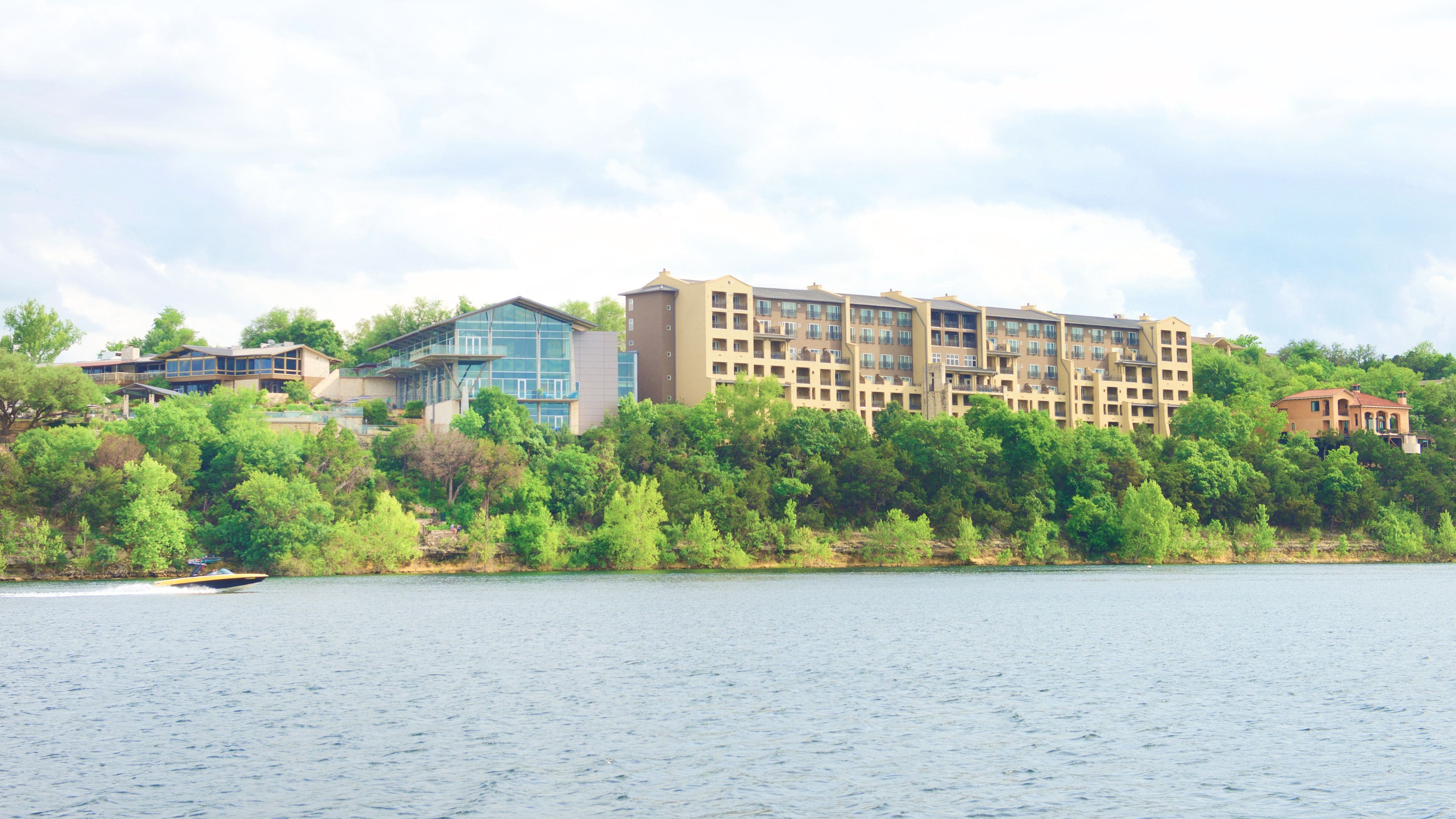 A multi-story hotel with a modern design, situated by a body of water.