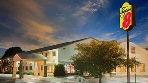 A motel with a Super 8 sign, a covered entrance, and a well-maintained lawn. - Super 8 by Wyndham Iowa Falls (Iowa Falls)