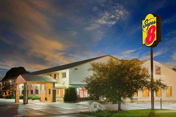 A motel with a Super 8 sign, a covered entrance, and a well-maintained lawn. - Super 8 by Wyndham Iowa Falls (Iowa Falls)