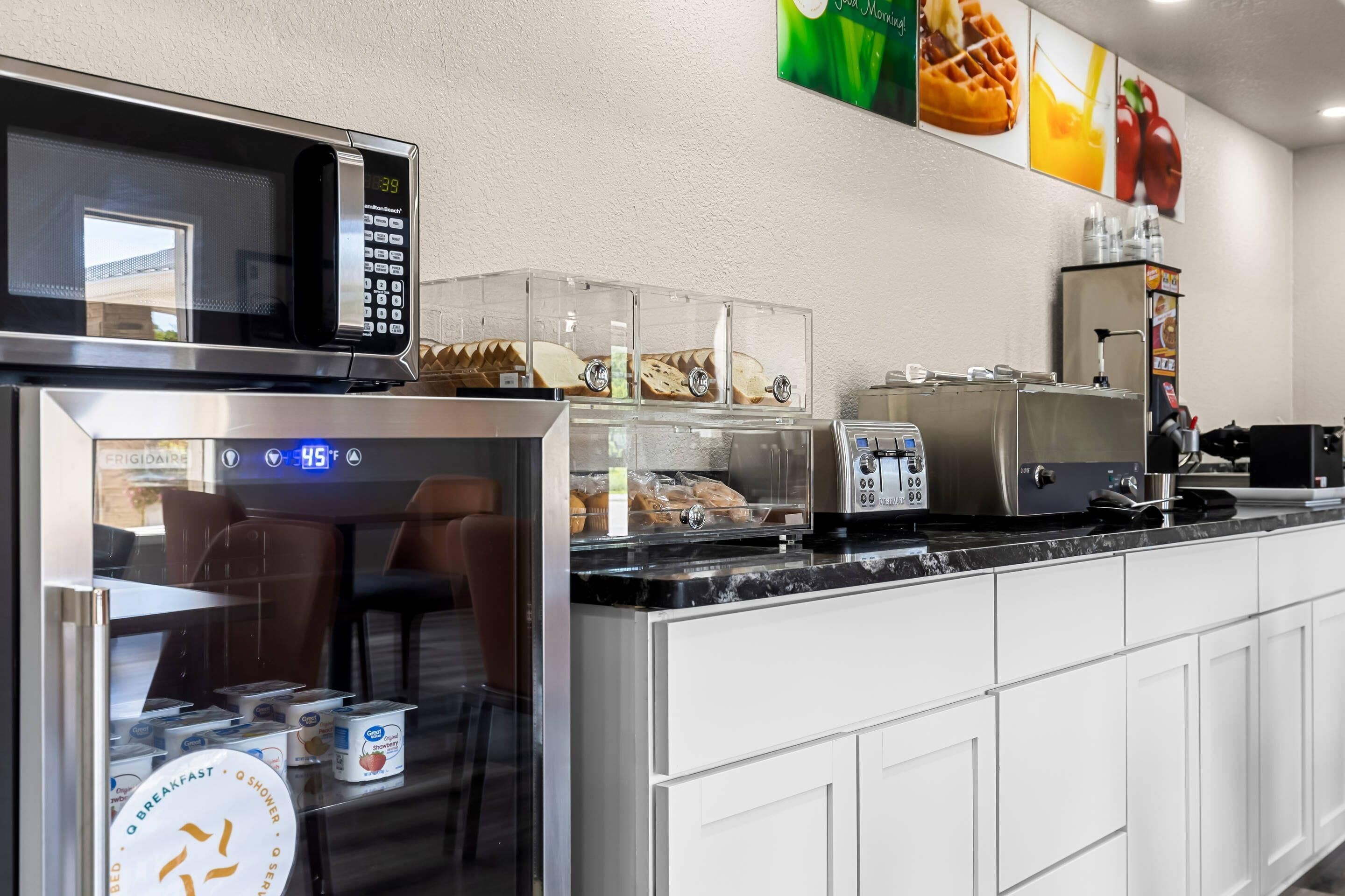 A kitchen area with a microwave, refrigerator, and a coffee machine.