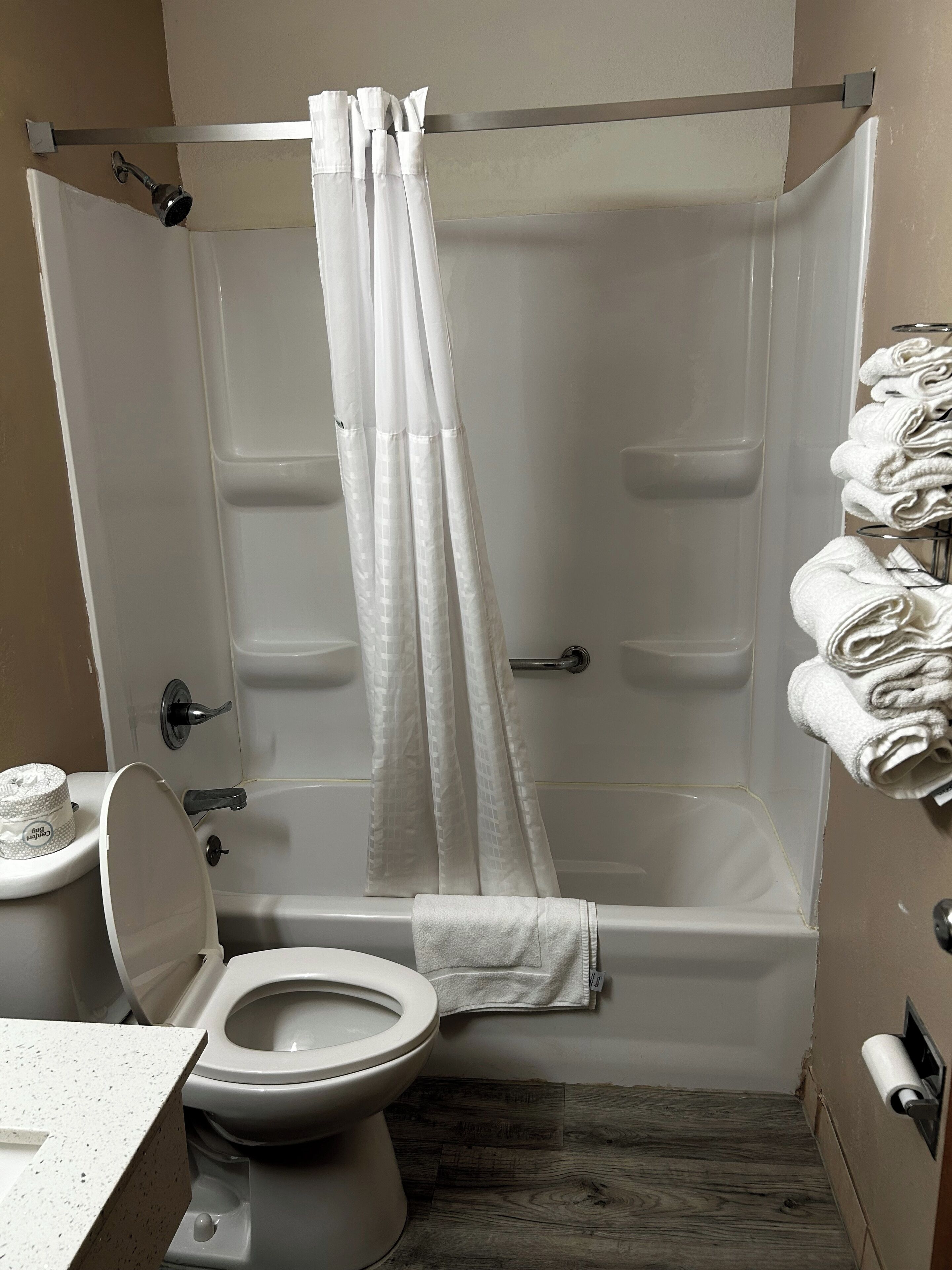 Een badkamer met douche, toilet en handdoekrek.