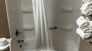 Een badkamer met douche, toilet en handdoekrek.