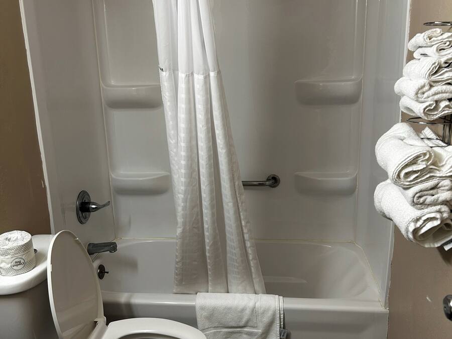Een badkamer met douche, toilet en handdoekrek.