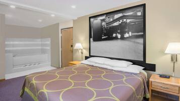 Une chambre d’hôtel avec un grand lit, une baignoire et un téléviseur fixé au mur.