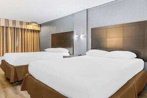 A hotel room with two beds, a large mirror, and a curtain.