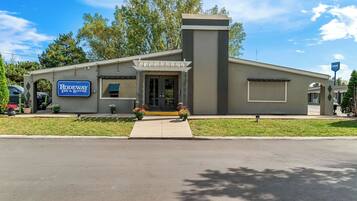 Standalone motel with a modern design, featuring a flat roof, covered entrance, and a large window.