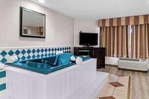 Un baño moderno con una bañera grande, un espejo, un televisor y un aire acondicionado.