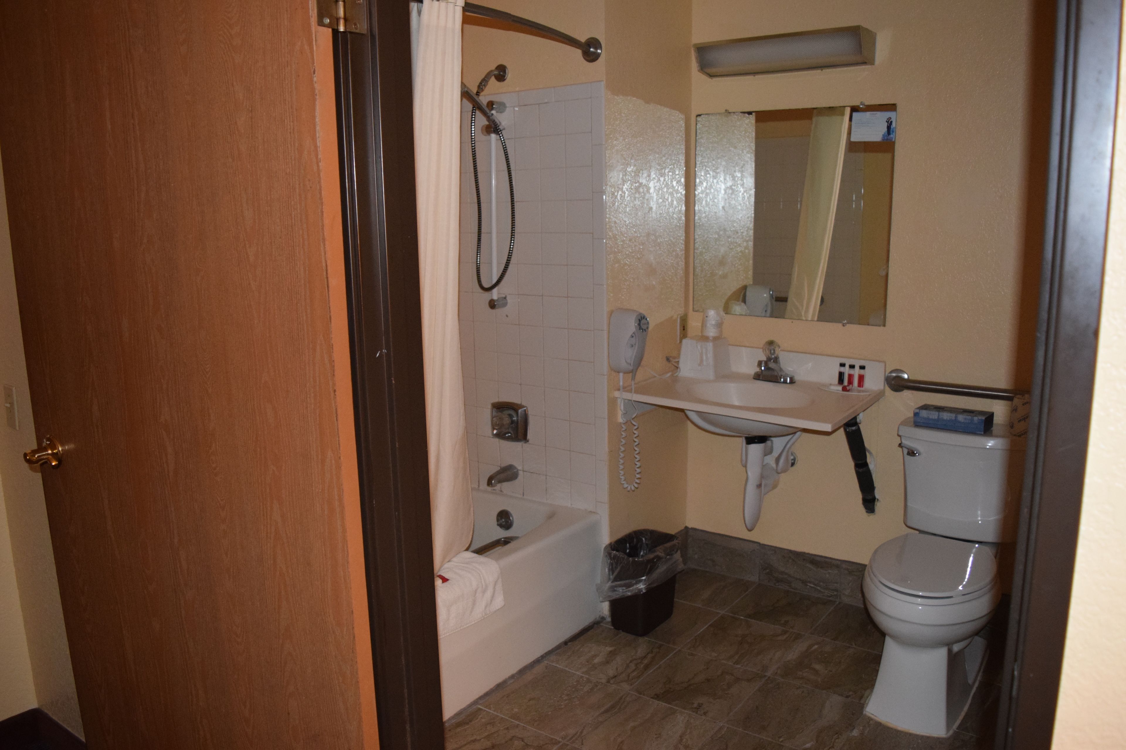 Un baño con bañera, inodoro, lavamanos y ducha con cortina.