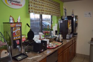 Un rincón para el desayuno con cafetera, refrigerador y ventana con vistas al exterior.