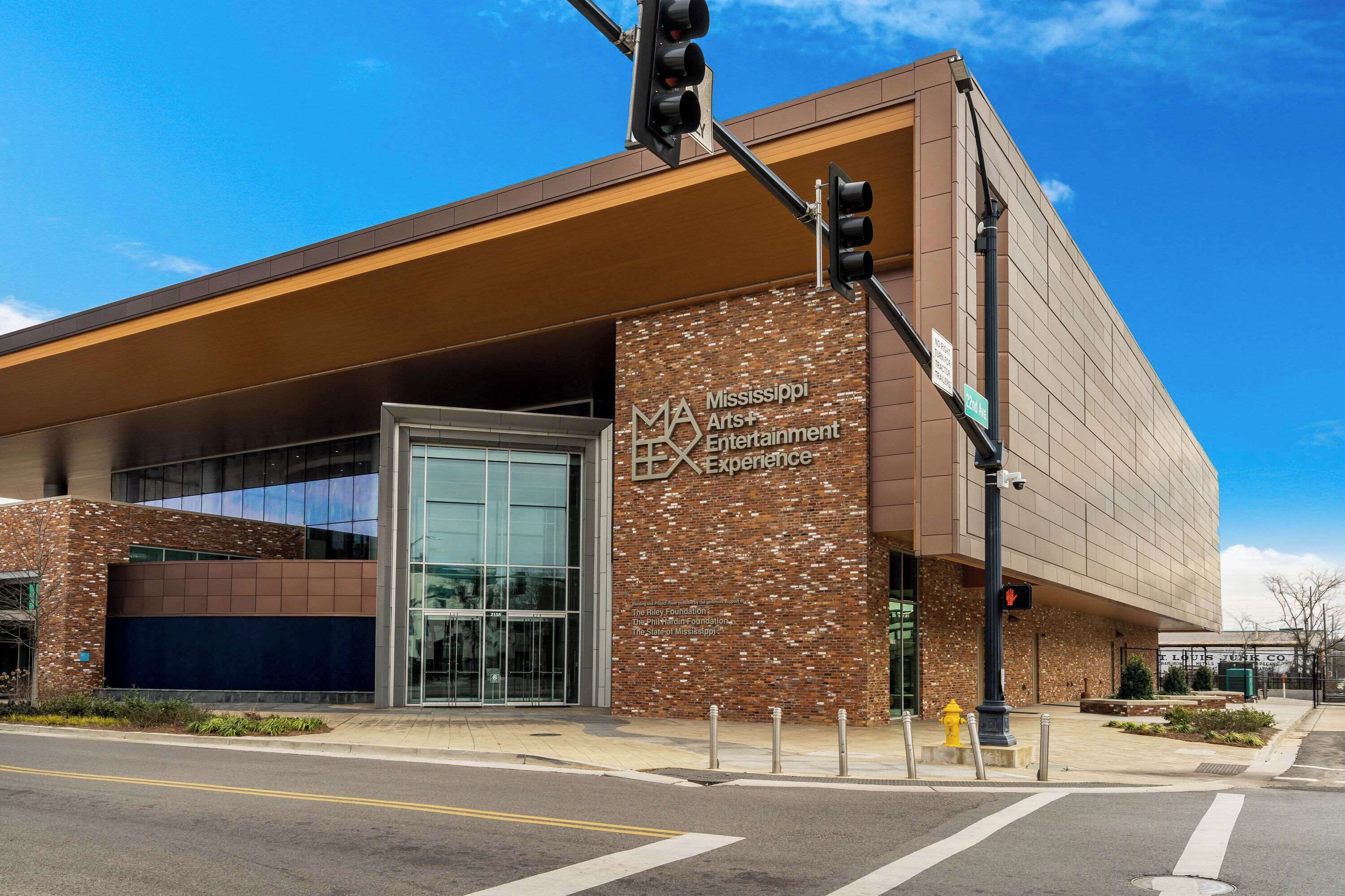 A modern building with a glass entrance and signage for Mississippi Arts & Entertainment.