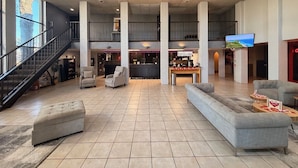 A spacious lobby with a staircase, seating area, and a coffee bar. - Mariposa Hotel (Nogales)