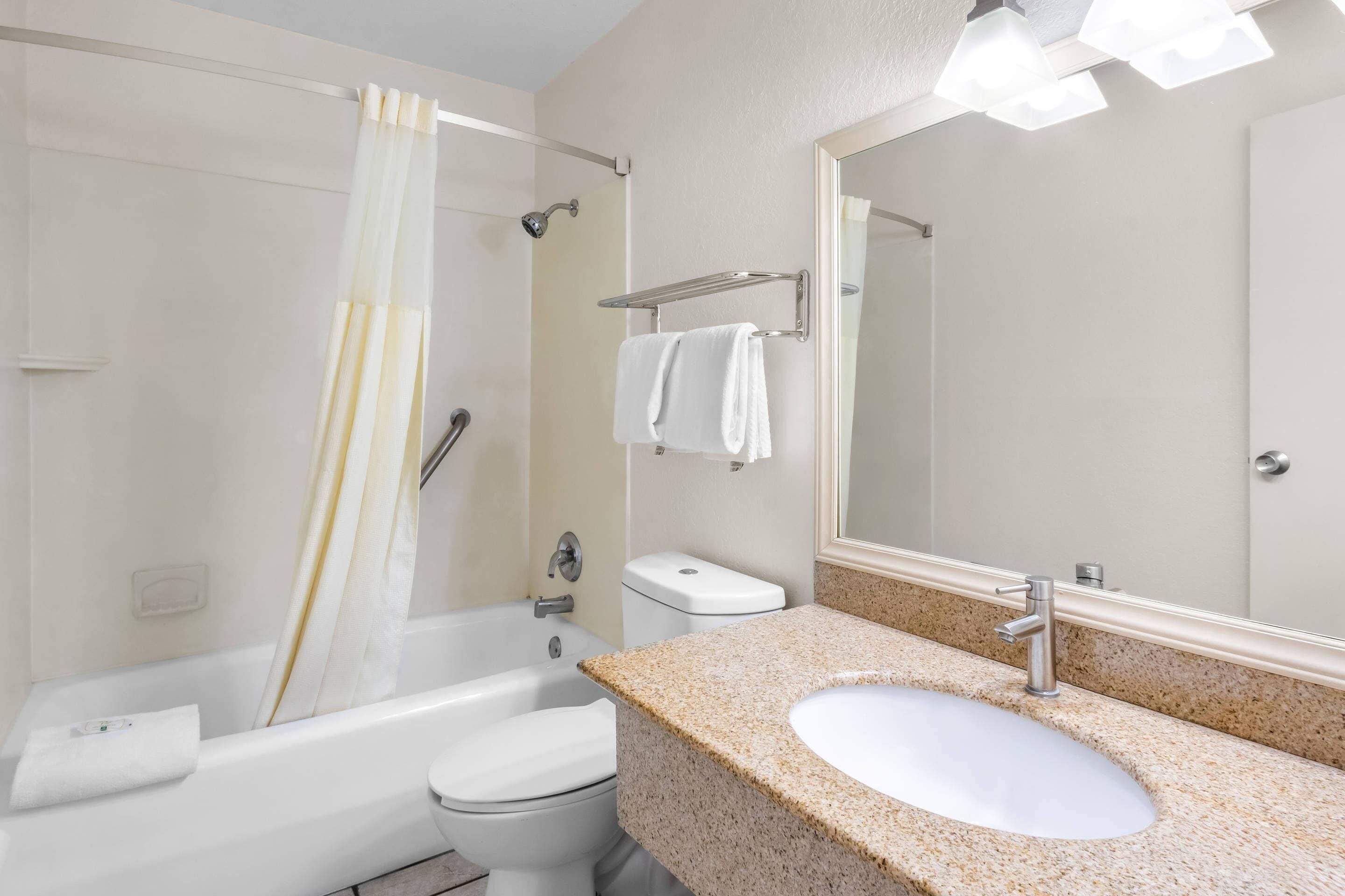A modern bathroom with a bathtub, toilet, and sink.