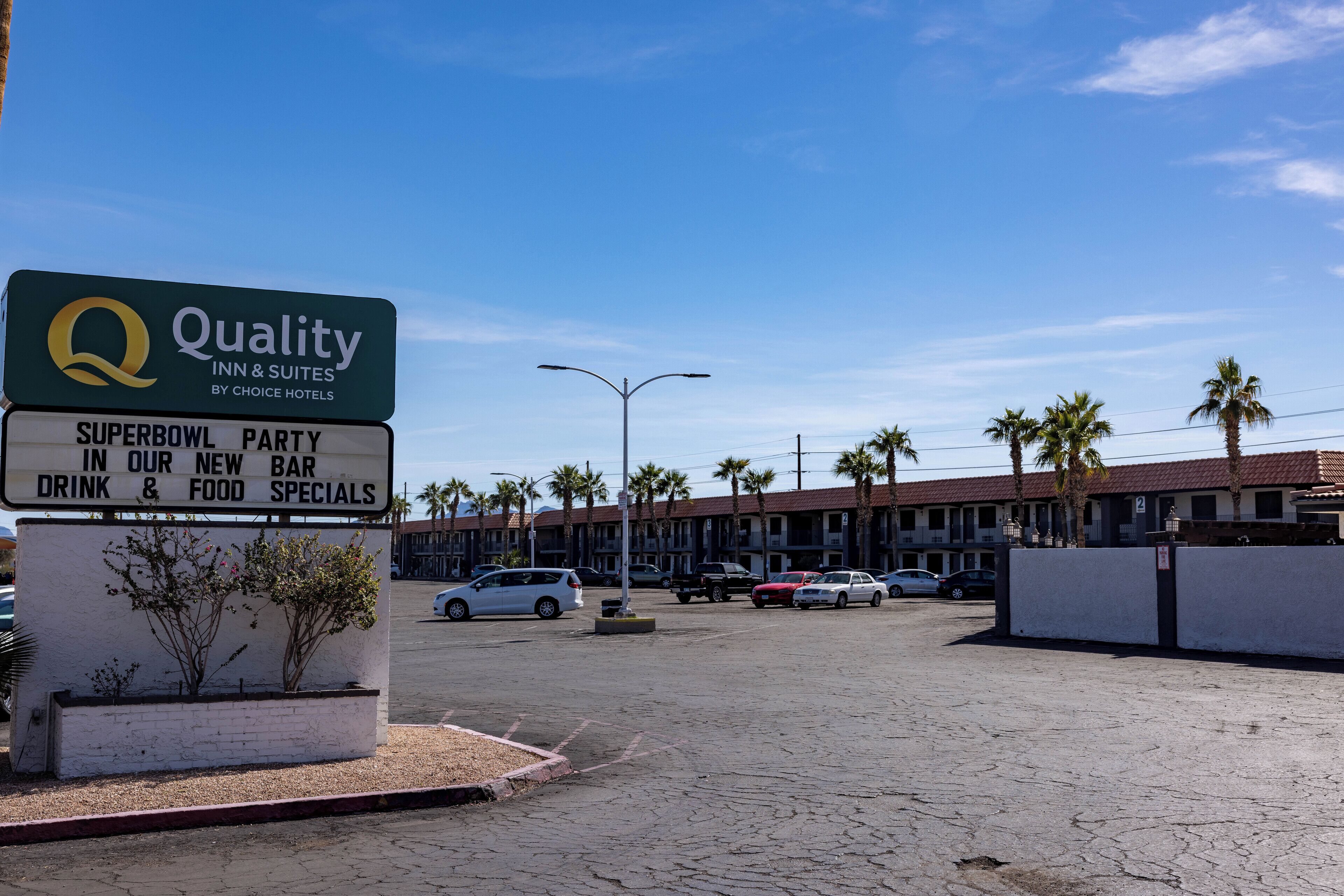 A hotel sign advertising a Super Bowl party, new bar, and food specials.