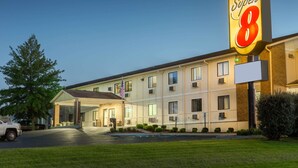 A Super 8 hotel with a large sign, a covered entrance, and a parking lot.