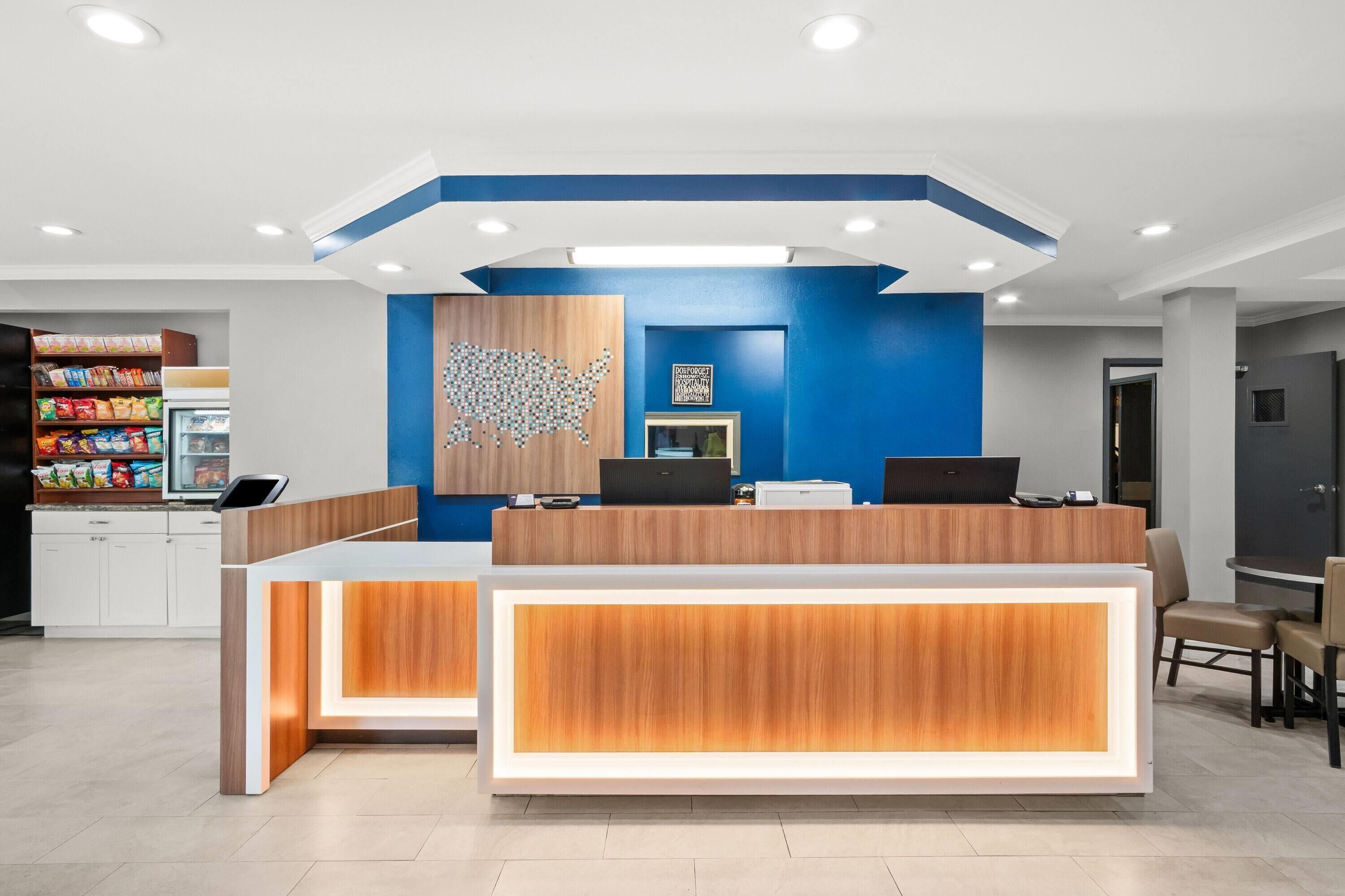 A modern reception desk with a blue accent wall and a wooden panel design.