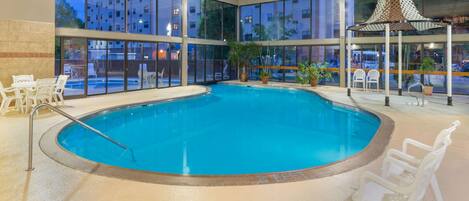 Alberca techada, alberca al aire libre y camastros