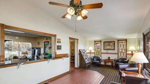 A hotel lobby with a reception desk, seating area, and a ceiling fan. - Knights Inn Ashland (Ashland)