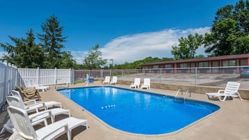 Una piscina al aire libre de temporada, sillones reclinables de piscina