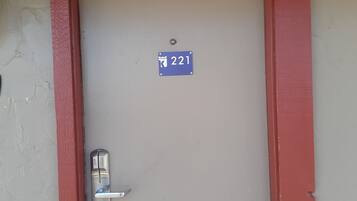 Una puerta con un letrero azul que indica el número de habitación 221.