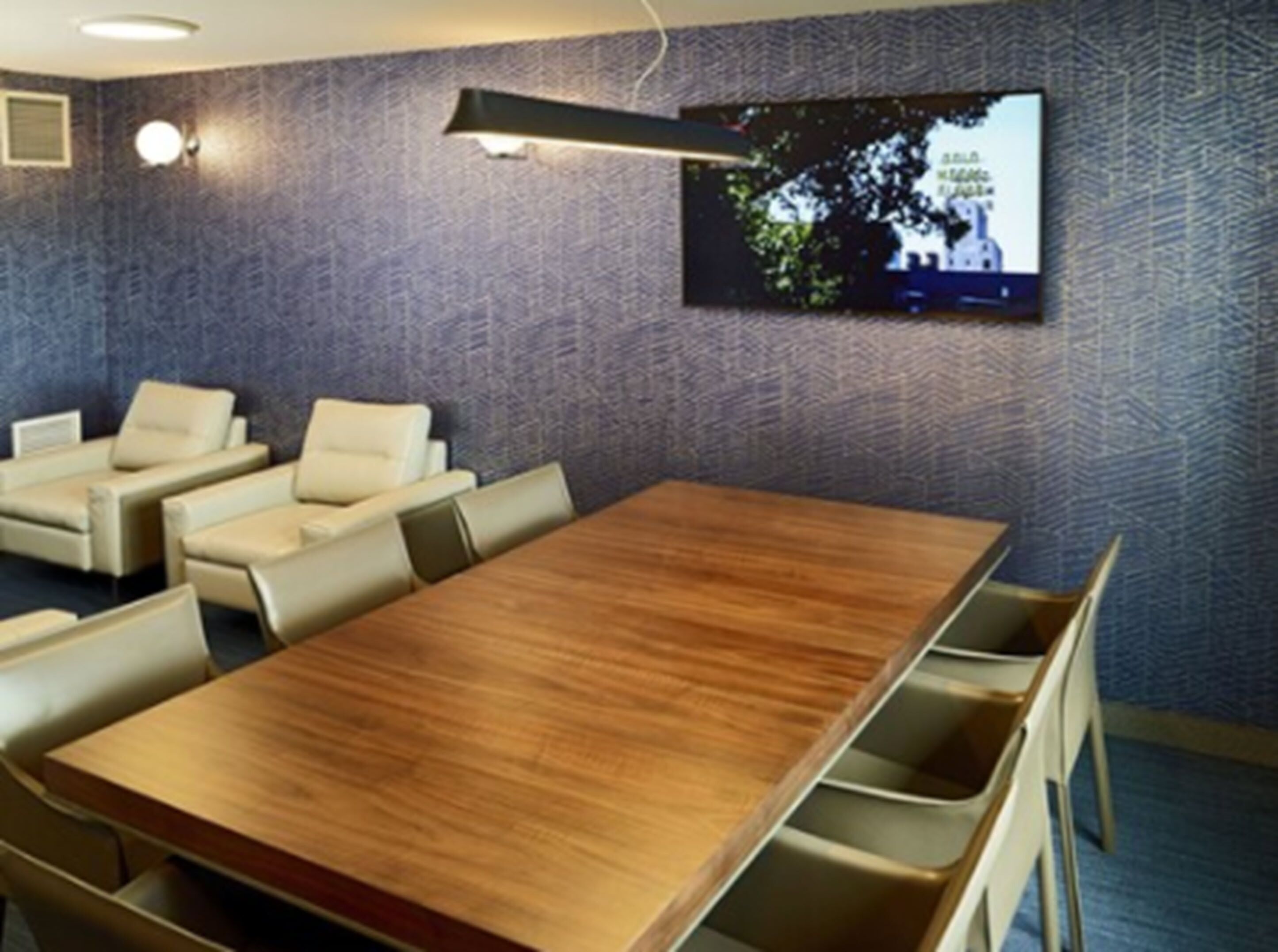 Uma sala de conferências com uma mesa de madeira e cadeiras bege.