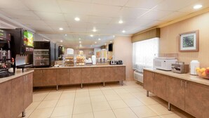 A modern kitchen area with a central island, equipped with various appliances and a display of baked goods. - La Quinta Inn by Wyndham Minneapolis Airport Bloomington (Bloomington)