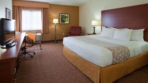 A hotel room with a large bed, a desk with a computer, a chair, and a TV. - La Quinta Inn by Wyndham Minneapolis Airport Bloomington (Bloomington)