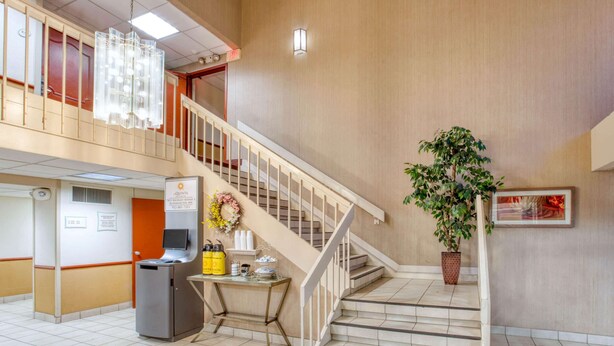 A hotel lobby with a staircase, a reception desk, a vending machine, and a potted plant. - La Quinta Inn by Wyndham Minneapolis Airport Bloomington (Bloomington)