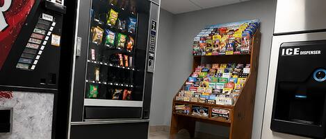 A vending machine area with a selection of snacks and a display of magazines.