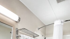 Un baño con lavamanos de granito, inodoro, bañera y cortina de ducha.