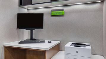 Escritorio de centro de negocios con monitor de computadora, teclado, ratón e impresora HP.