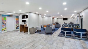 Un hall de hotel con una recepción, zona de estar y un amplio ventanal.