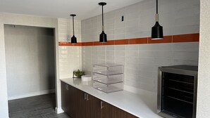 Una cocina moderna con encimera blanca, armarios de madera y horno integrado.