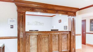 A reception desk with a 'Manager on Duty' sign, a 'Baymont' logo, and a 'Welcome' sign.
