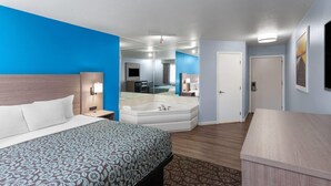 Une chambre d’hôtel dotée d’un grand lit, d’une salle de bain séparée avec une baignoire et d’un espace bureau.