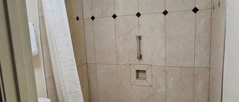 A bathroom with a bathtub, toilet, and shower curtain.