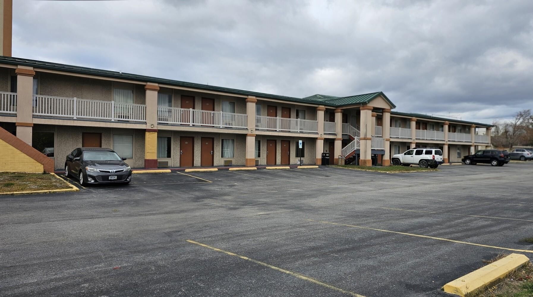 A motel with multiple rooms, a parking lot, and a covered walkway.