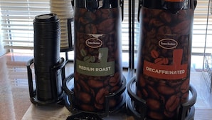 Two coffee machines labeled 'Medium Roast' and 'Decaffeinated' by Farmer Brothers, with coffee pods and a waffle iron on a countertop. - Super 8 by Wyndham Yucca Val/Joshua Tree Nat Pk Area (Yucca Valley)