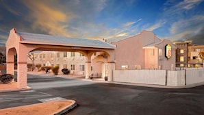 A hotel entrance with a covered driveway, a sign indicating 'Clearance 11', and a 'Super 8' sign on the building. - Super 8 by Wyndham Yucca Val/Joshua Tree Nat Pk Area (Yucca Valley)