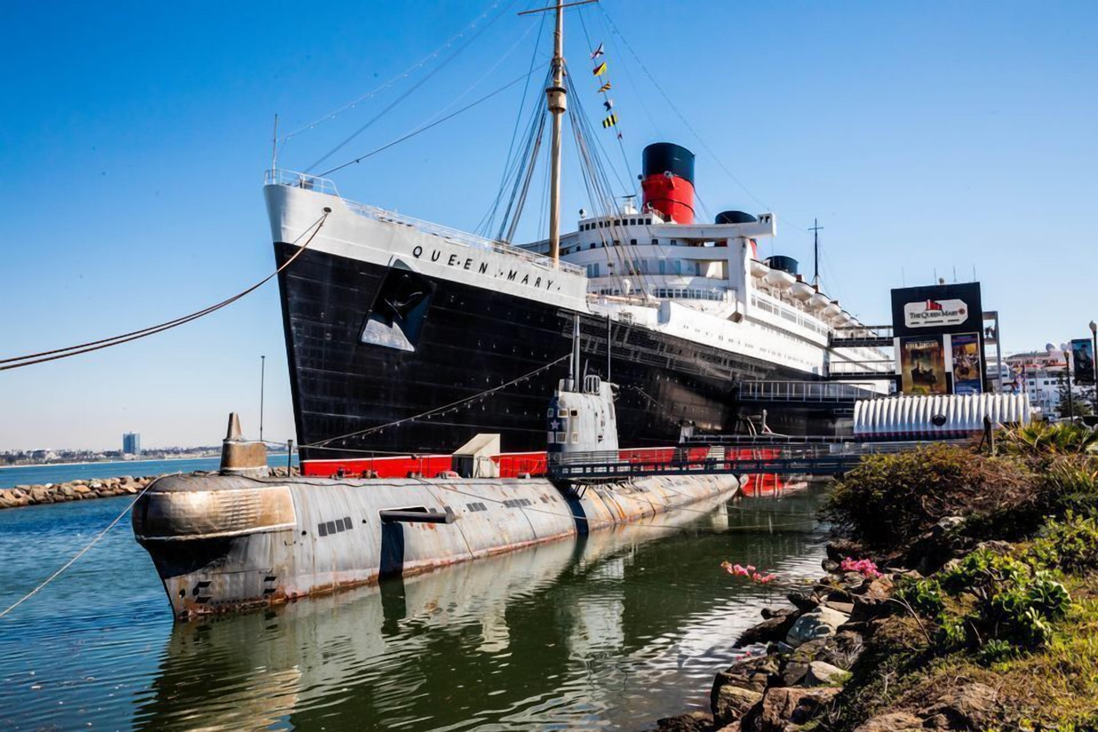 Un gran barco oxidado llamado QUEEN MARY atracado en un puerto.