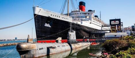 Un gran barco oxidado llamado QUEEN MARY atracado en un puerto.